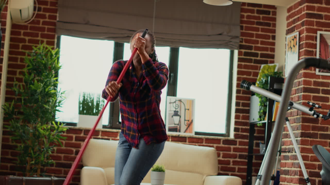 Female adult dancing and having fun cleaning household