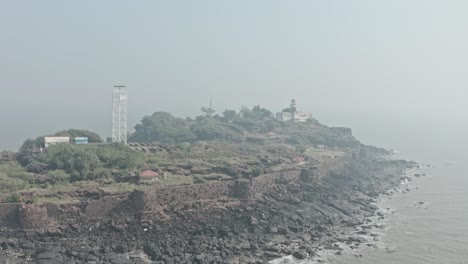 Dolly-forward-drone-shot-towards-island-with-Light-house-radar-and-solar-panels