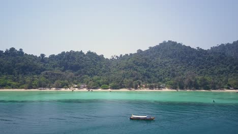 toma aérea de una isla exuberante con playa y hermosas aguas en tailandia