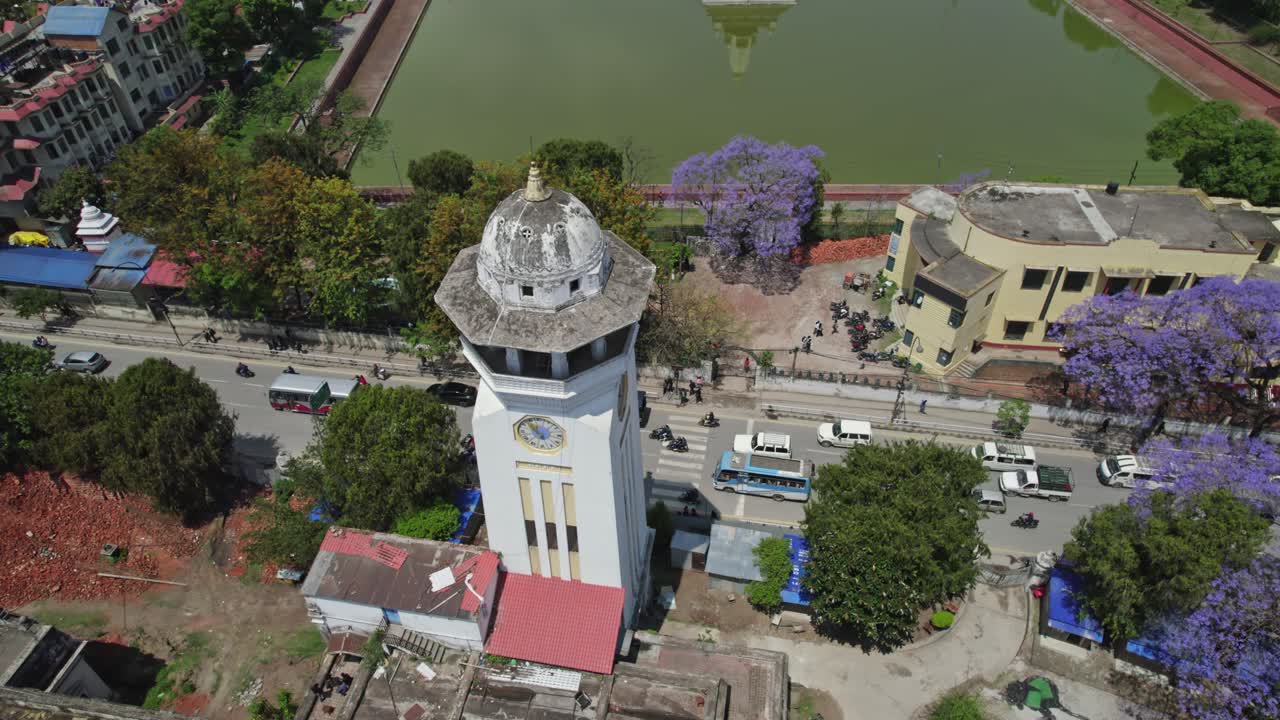Drone view of Kathmandu Valley featuring Rani Pokhari, Ghantaghar, and blooming Jacaranda flowers, showcasing the valley’s rich heritage, colors, and timeless urban charm