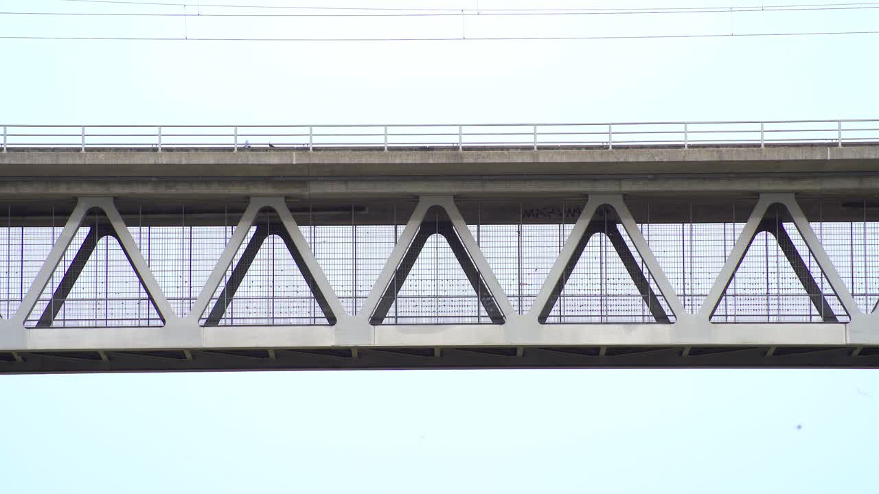 두 마리의 비둘기가 강철 건설 철교에 앉아 날아가고 있다