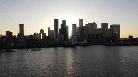 Aerial---Sunset-on-the-River-Thames-and-Canary-Wharf,-London,-wide-lowering-shot