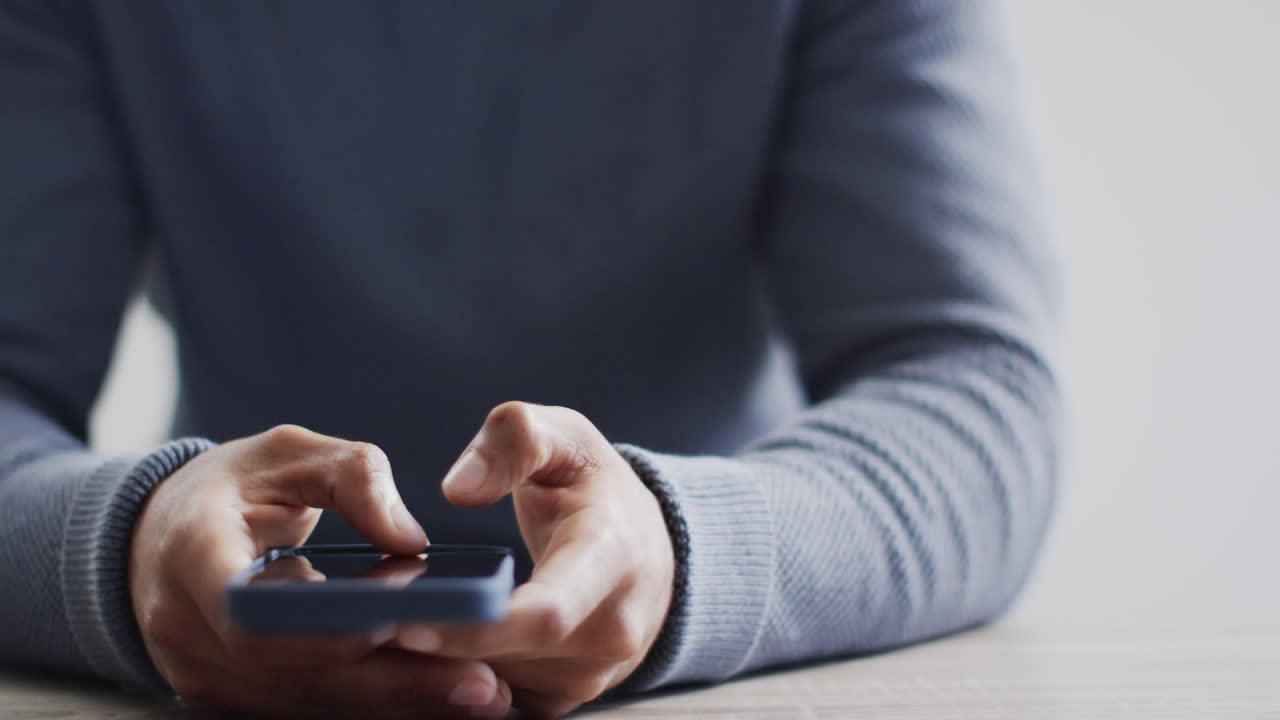 스마트폰을 이용한 책상에 앉아 있는 두 인종 사업가 중간 섹션의 비디오