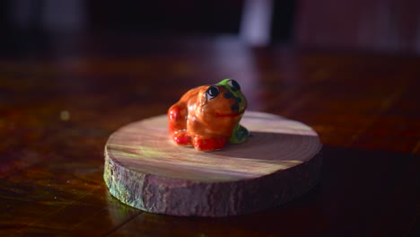 Ceramic-frog-showpiece-on-a-sliced-wood-base-with-illuminating-lights---4k