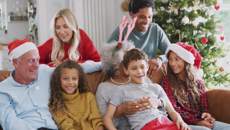 Retrato-De-Una-Familia-Multigeneracional-Sentada-En-Un-Sofá-Celebrando-La-Navidad-Juntos