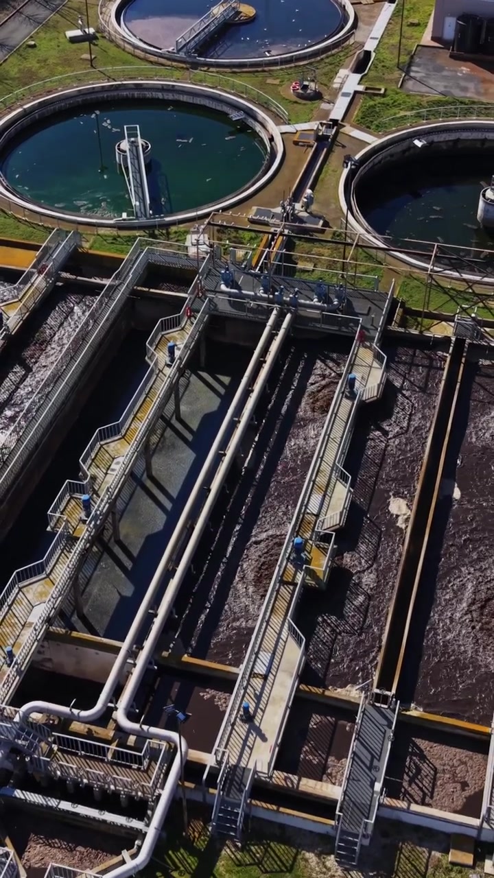 Water treatment facility processing water in circular tanks during daylight