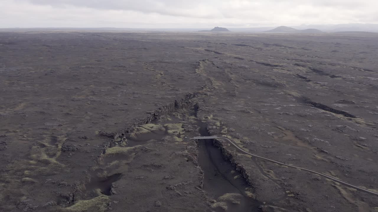 Aerial of barren black landscape with volcanic surface in Iceland at peninsula