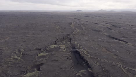 aerial of barren black landscape with volcanic surface in iceland at peninsula