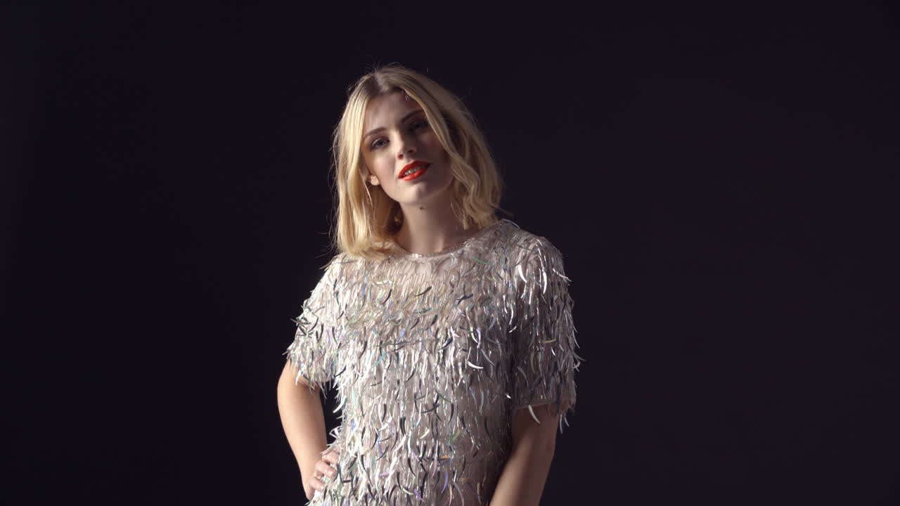 반이는 드레스를 입은 매력적인 여성이 몸을 돌리고 허리를 들어 올립니다.