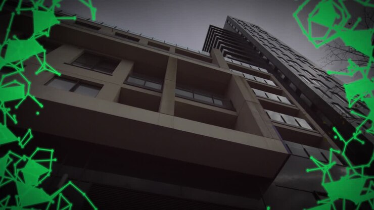Cámara en ángulo bajo inclinándose hacia arriba y avanzando, red verde creciendo hacia dentro, encuadrando el edificio
