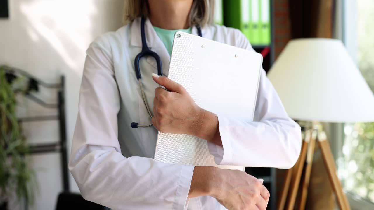 A doctor in a white coat holding a clipboard