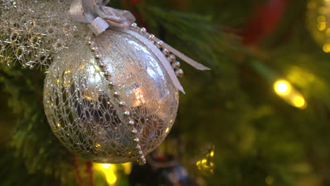 rack focus close up of a silver ornament on a christmas tree