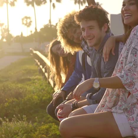 young people sitting on wooden fence