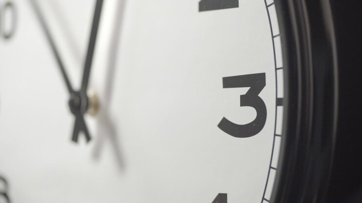 White Clock Face Close Up in Time Lapse on Dark Grey Wall