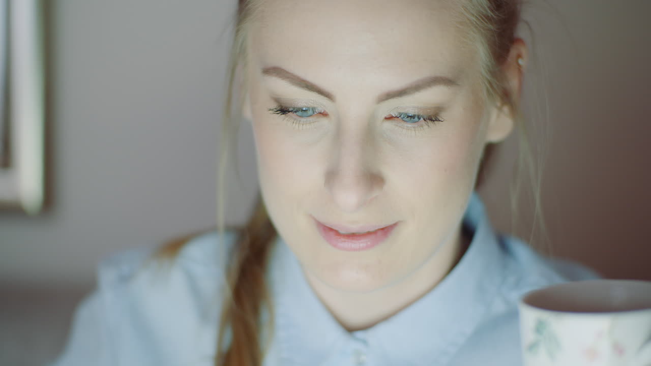 женщина, работающая поздно ночью с чаем в офисе.