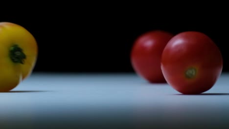 heirloom tomatoes, cherry tomatoes fall on a white surface in studio view