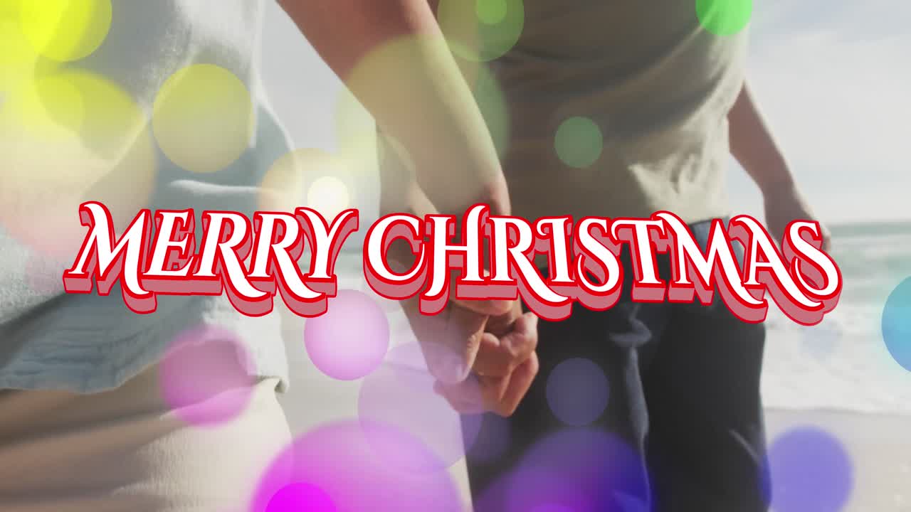 해변에서 시니어 이중 인종 부부 위에 메리 크리스마스 텍스트의 애니메이션