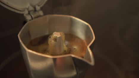 making espresso coffee in moka pot on electric stove - closeup