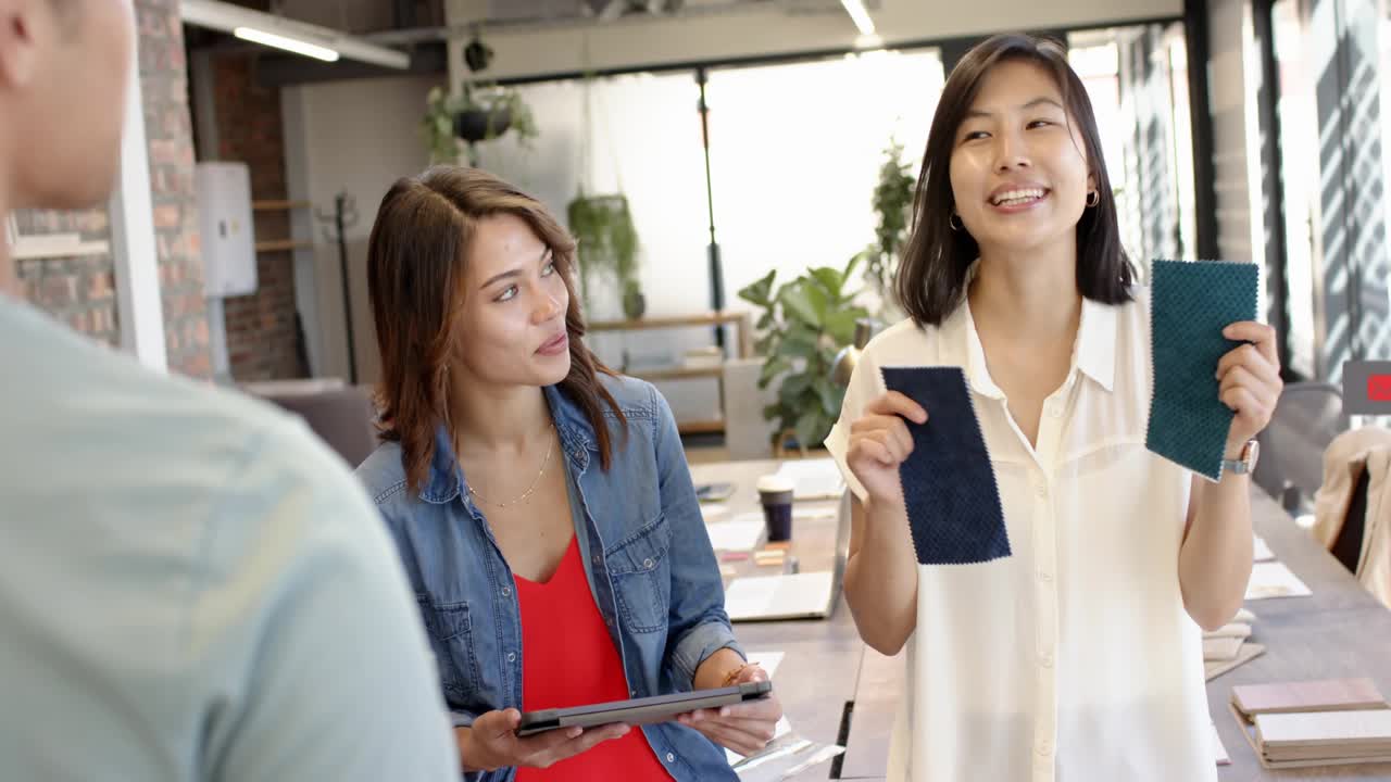 Two women showing swatches for design decision in studio, initiating social icons overlaying scene
