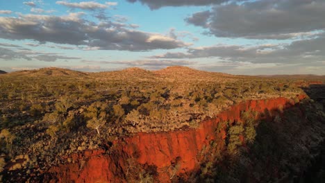 Aerial-flight-alone-red-cliffs-and-green-nature-at-sunset-time---Dales-Gorge,-Karijini-Area,-Western-Australia