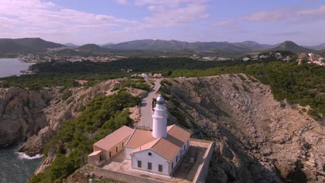 discover the breathtaking landscape of cala rajada, featuring a picturesque lighthouse surrounded by rugged cliffs and lush greenery. this serene destination in mallorca is perfect for nature lovers.