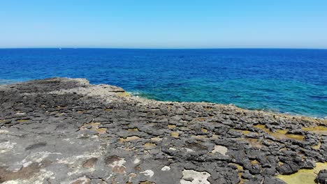 Luftaufnahme-Des-Smaragdblauen-Strandes-Aus-Felsigem-Kalkstein-An-Der-Küste-Von-Sliema,-Malta,-Rückwärts-Ansteigend,-4k