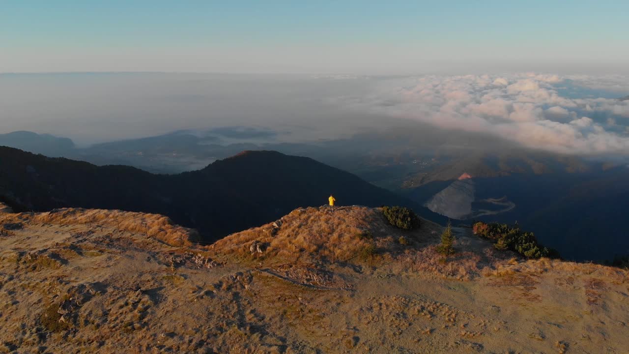 Uomo che osserva scogliere coperte di nebbia su un altopiano montano, Velika Planina, Slovenia