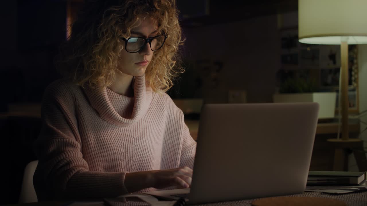 video de una mujer cansada trabajando hasta tarde en casa