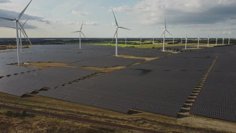 solar panels and wind turbines in the countryside producing clean energy in vemb and holstebro, denmark