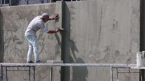 person climbs a tall concrete wall steadily