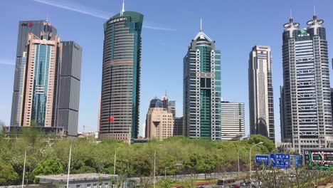 the road with a lot of cars and traffic jam under the skyscrapers in pudong, shanghai, china