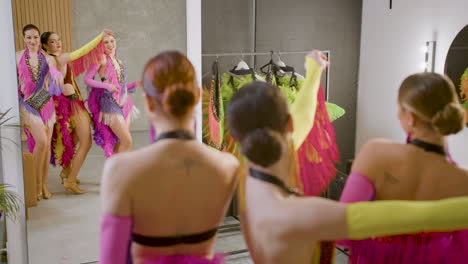 three beautiful girls practicing dance looking at the mirror before the cabaret show