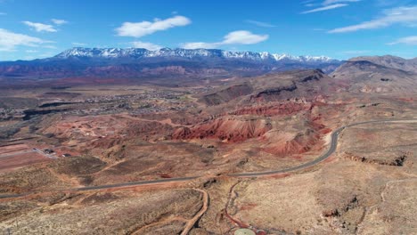 Drone-shot-of-a-busy-highway-in-the-desert-with-mountains-in-the-distance