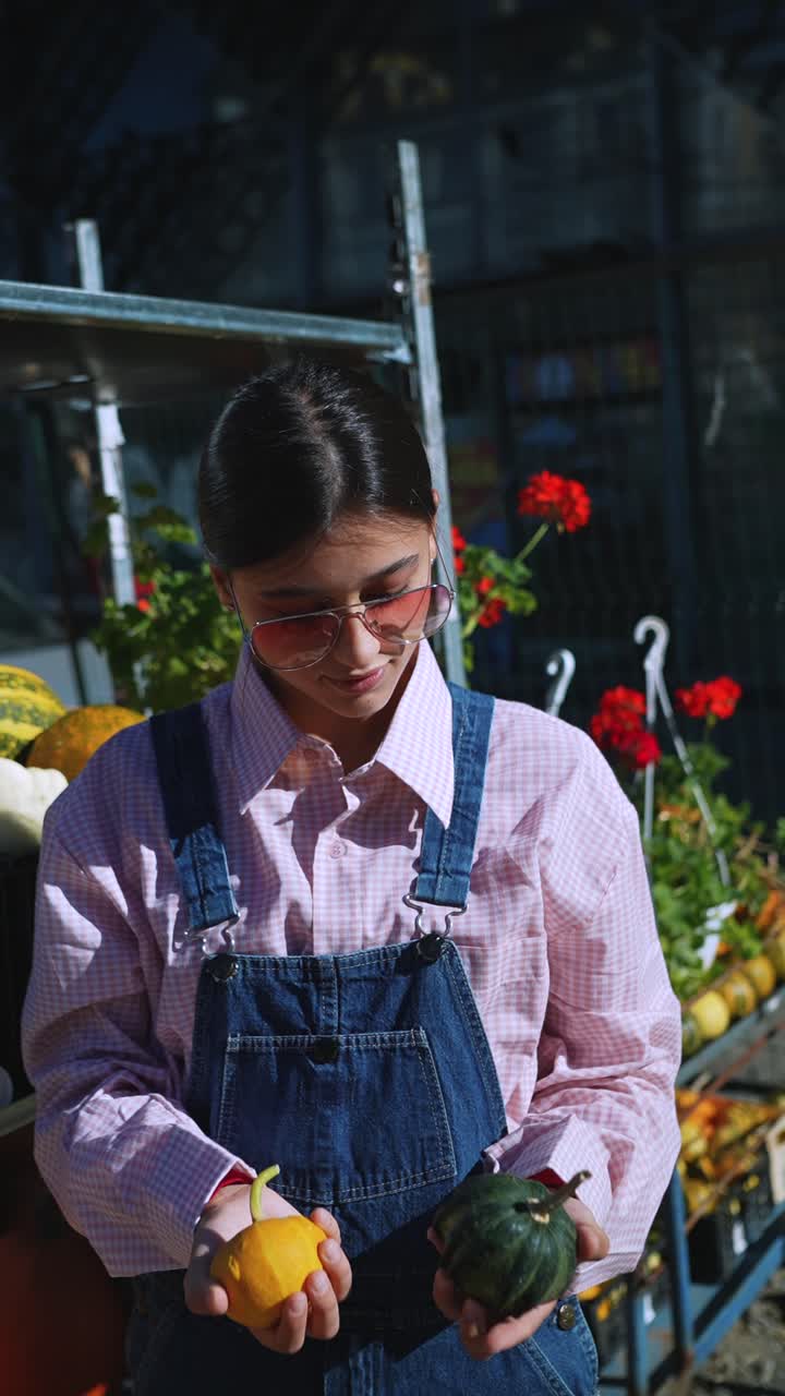 joven con calabazas en el mercado de un granjero