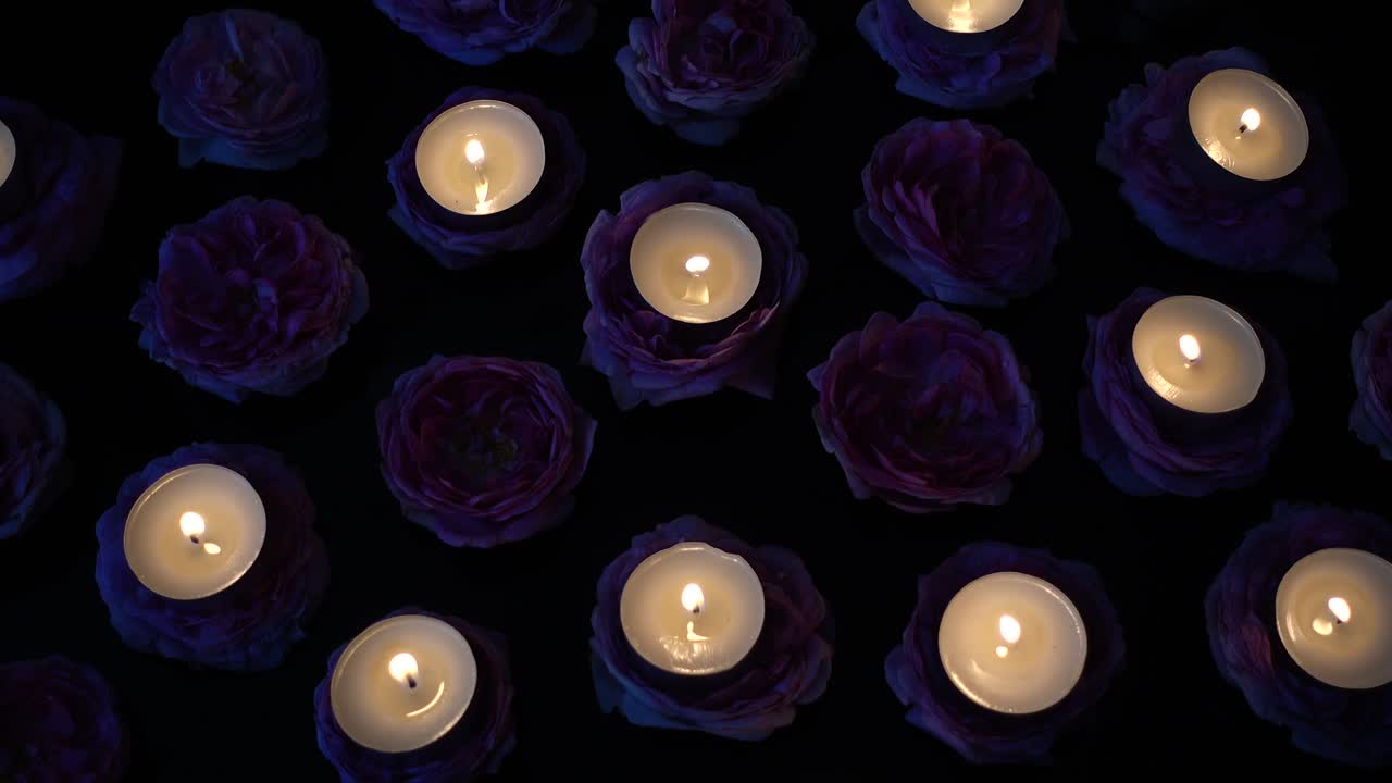 rosas y velas sobre un fondo negro.