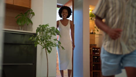 family returning home opening front door and children running in