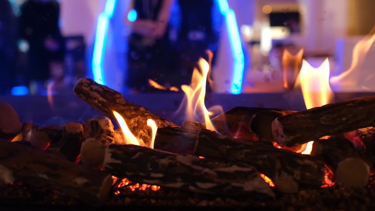 카메라 트럭은 현대적인 벽난로에서 천천히 불꽃을 남겼다, 배경에 조명과 함께 밤에 실내, 가까운 4k