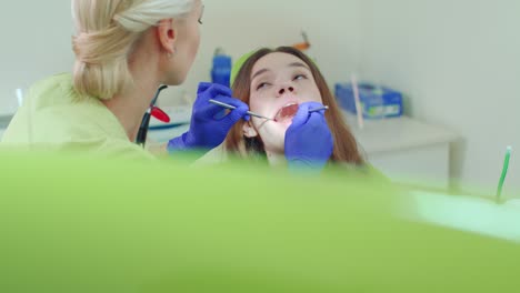 Niña-Que-Se-Somete-A-Un-Chequeo-Dental-Regular.-Mujer-Joven-Visitando-A-Su-Dentista.