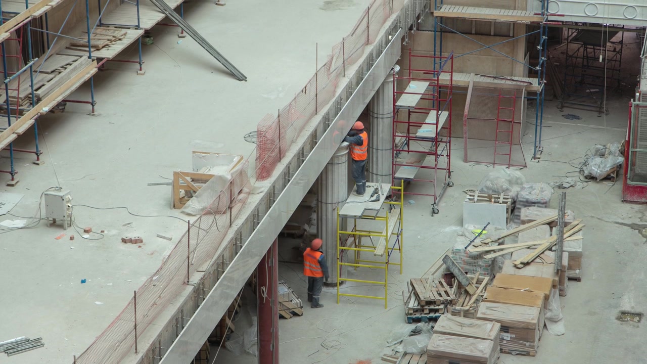 View from above of construction equipment material with scaffolding and tools inside the floor of high rising building timelapse, skyscraper. Building under construction. Interior work in progress