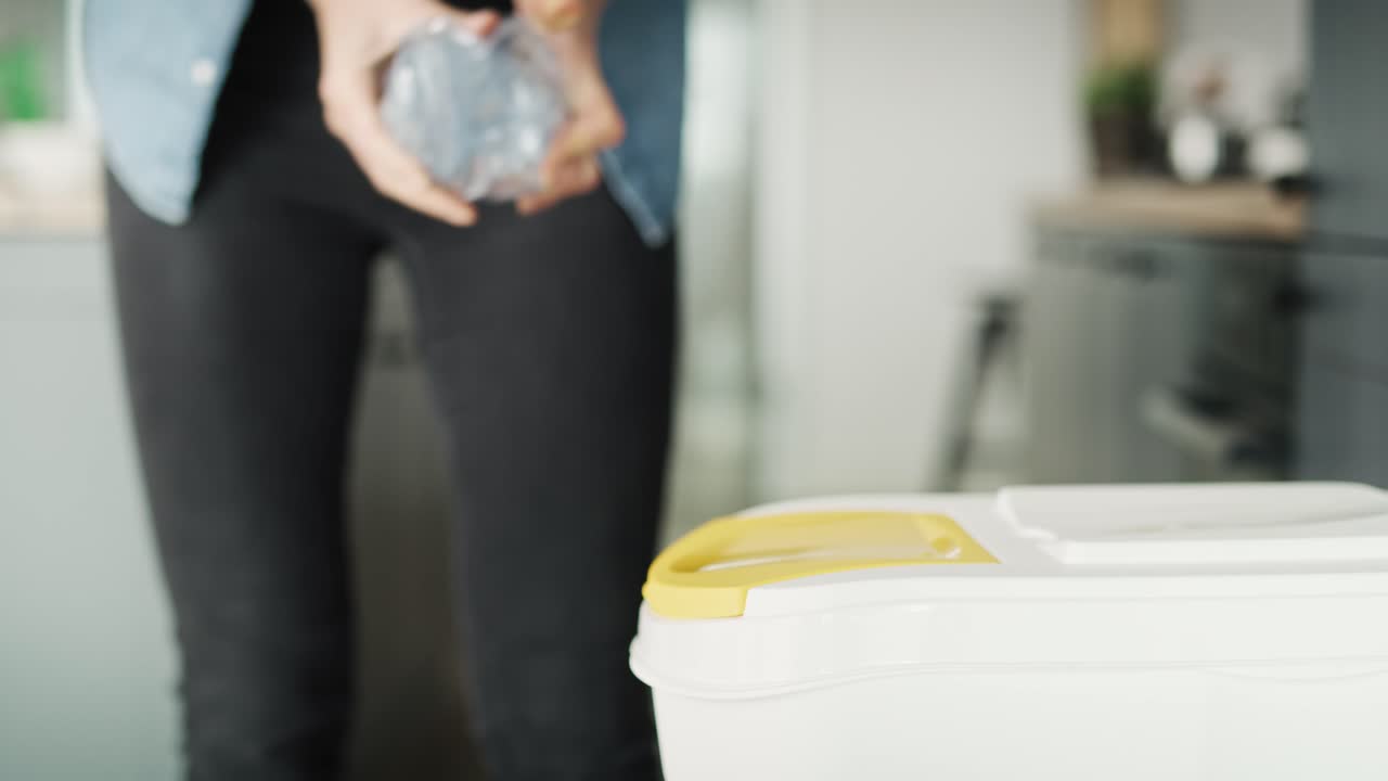 video de una mujer arrojando una botella de plástico en un contenedor de basura