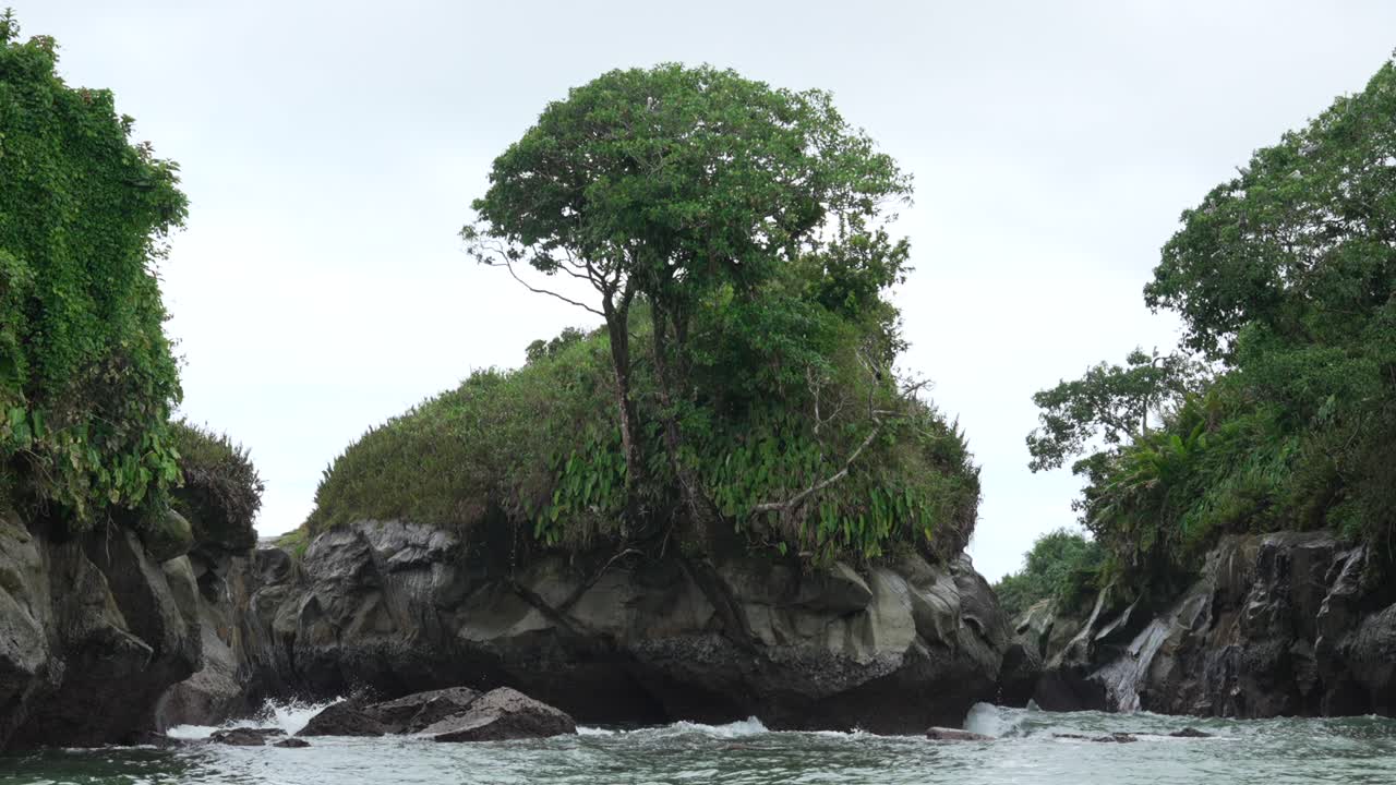Jungle-topped sea stacks form a narrow channel on Colombia’s Pacific at Juanchaco, shot from boat