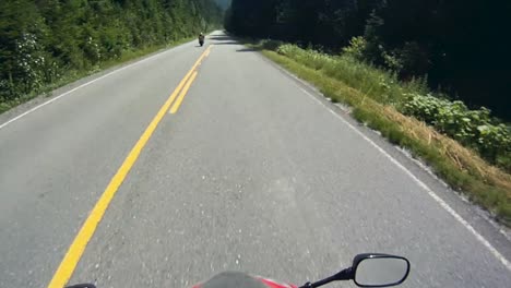 Clip-Pov-De-Un-Motociclista-En-Un-Sinuoso-Camino-Forestal-De-Montaña-En-El-Verano