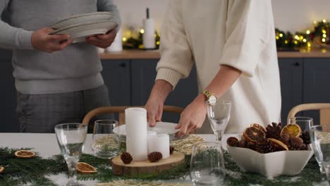 pareja preparando la mesa para la víspera de navidad