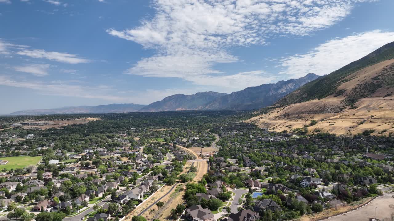 Aerial View of a Suburban Area with Mountains and Blue Sky