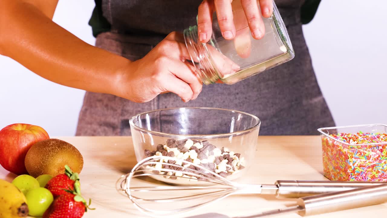 한 사람이 싱 보울에 초콜릿 을 넣습니다.