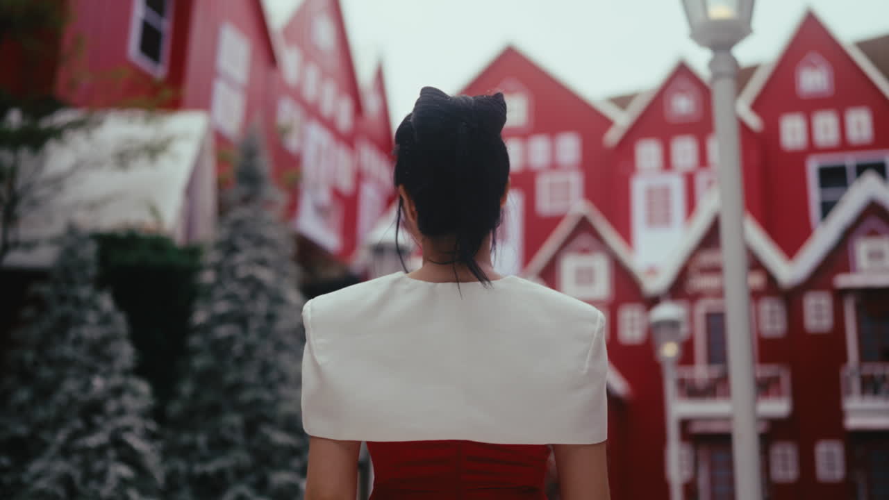 Woman in Red Dress in front of Christmas Village