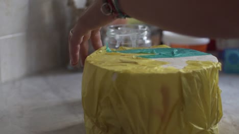 Close-up-slow-motion-of-woman-making-a-stand-for-hand-make-cake-pops,-using-a-styrofoam