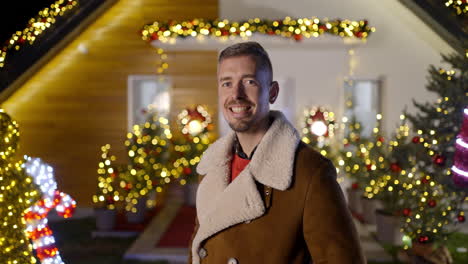 Festive man in front of a Christmas decorated house