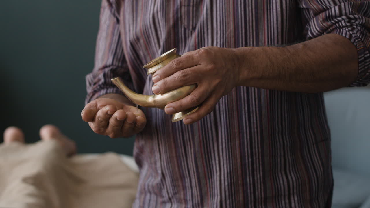 Hands pouring liquid from a vessel