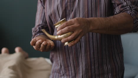 hands pouring liquid from a vessel